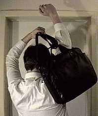 Stretch arms up and through
the shoulder strap.